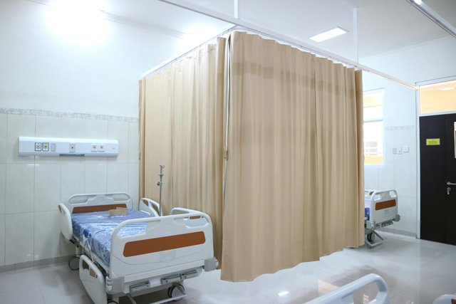 Habitación de hospital con cortina divisoria de privacidad