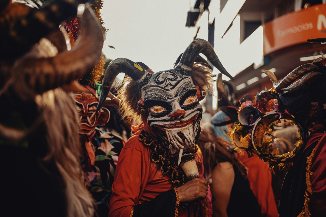Festividad tradicional ecuatoriana con máscaras y trajes típicos