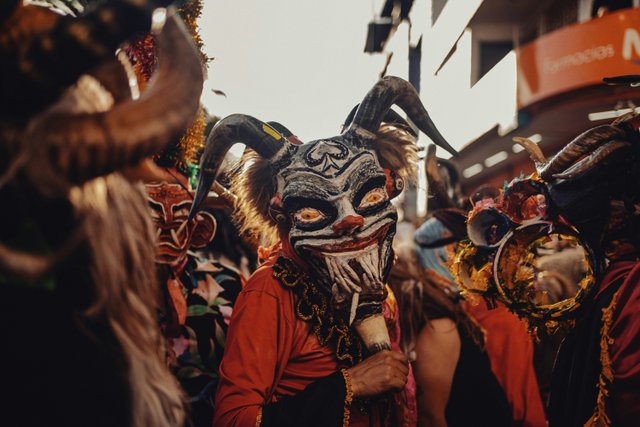 Festividad tradicional ecuatoriana con máscaras y trajes típicos