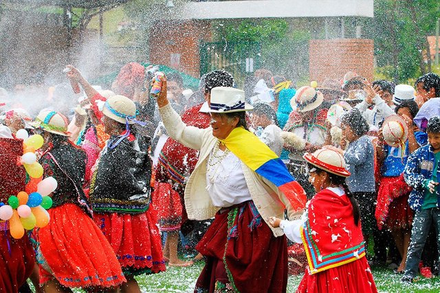 Celebración tradicional ecuatoriana con agua y confeti
