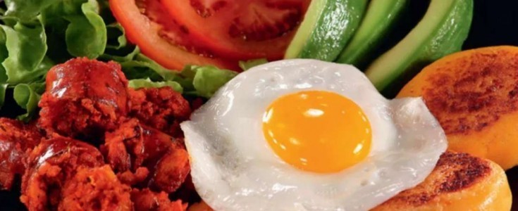 Llapingacho tradicional ecuatoriano con huevo y acompañamientos frescos