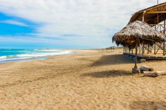 Playa virgen de la costa ecuatoriana con infraestructura turística tradicional