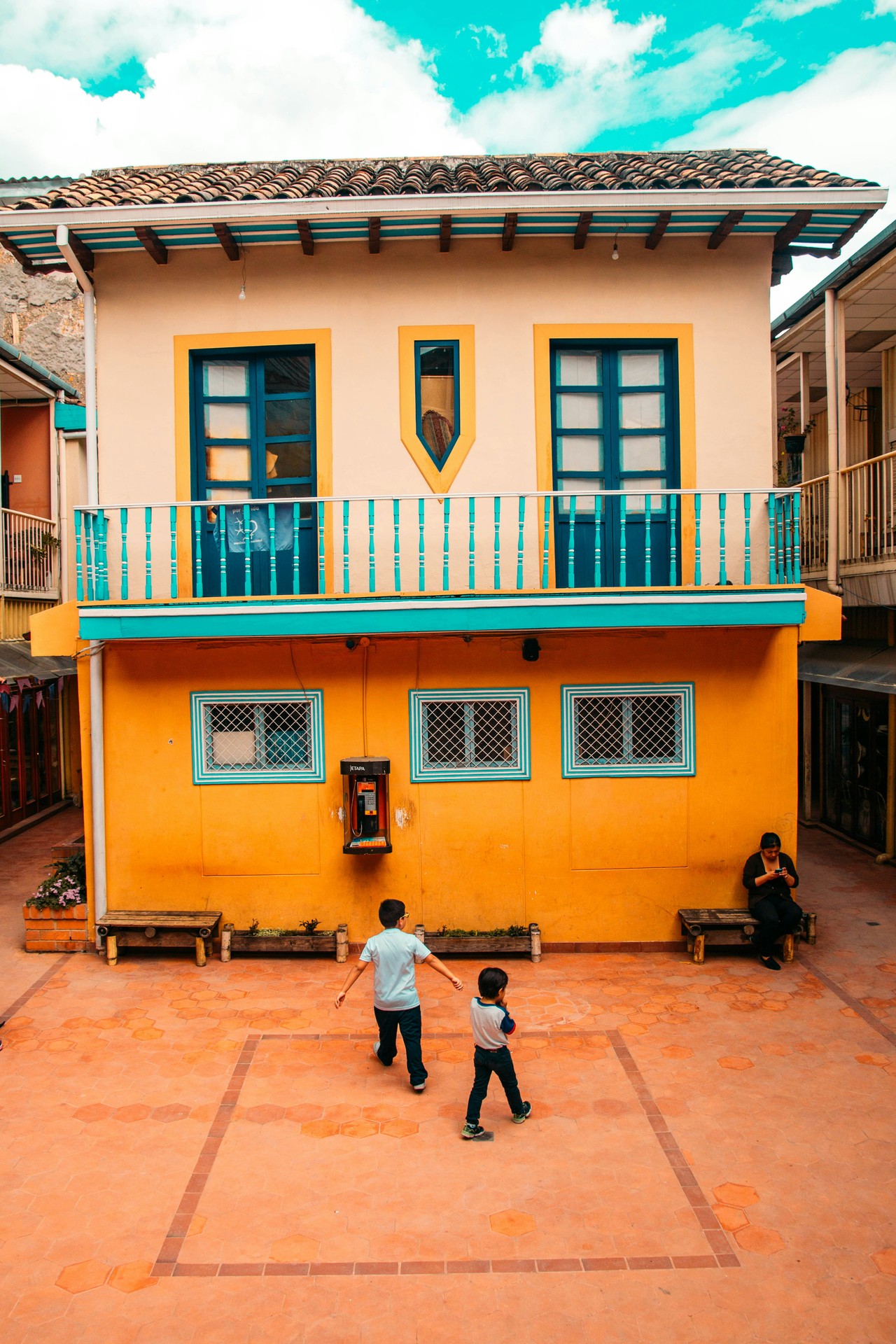 Escuela colonial en centro histórico ecuatoriano con estudiantes en patio