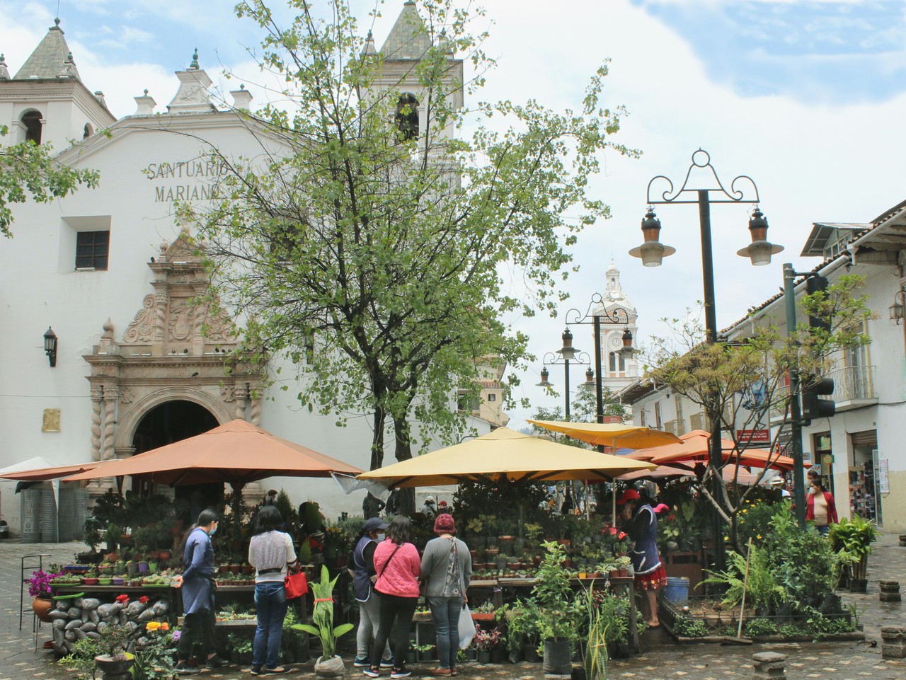 Mercado tradicional en plaza histórica de pueblo ecuatoriano