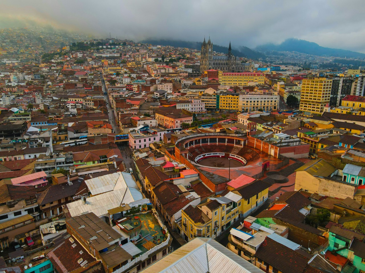 Vista aérea de Quito con la plaza de toros y montañas al fondo