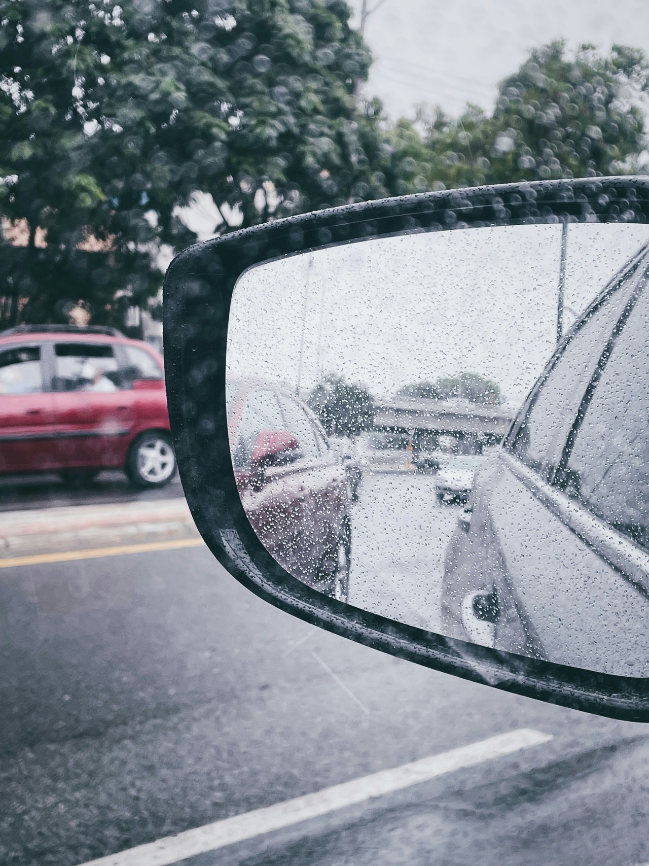 Espejo retrovisor con lluvia en carretera de Guayaquil