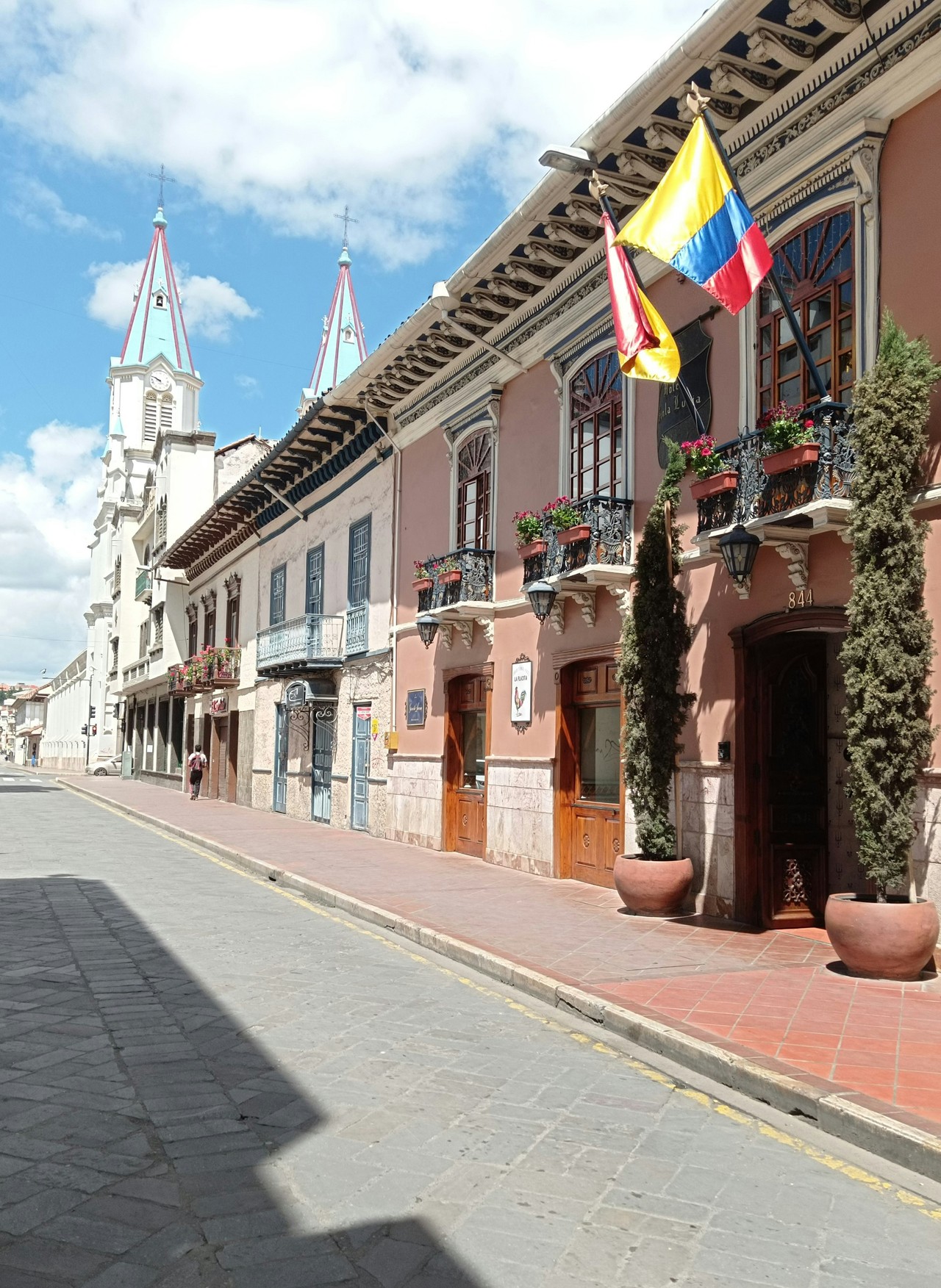 Calle colonial de Cuenca con arquitectura patrimonial y bandera ecuatoriana