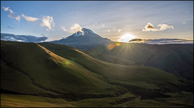 Volcán nevado ecuatoriano con rayos de sol al atardecer