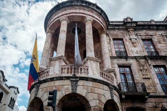 Fachada del Palacio Legislativo de Ecuador con bandera nacional