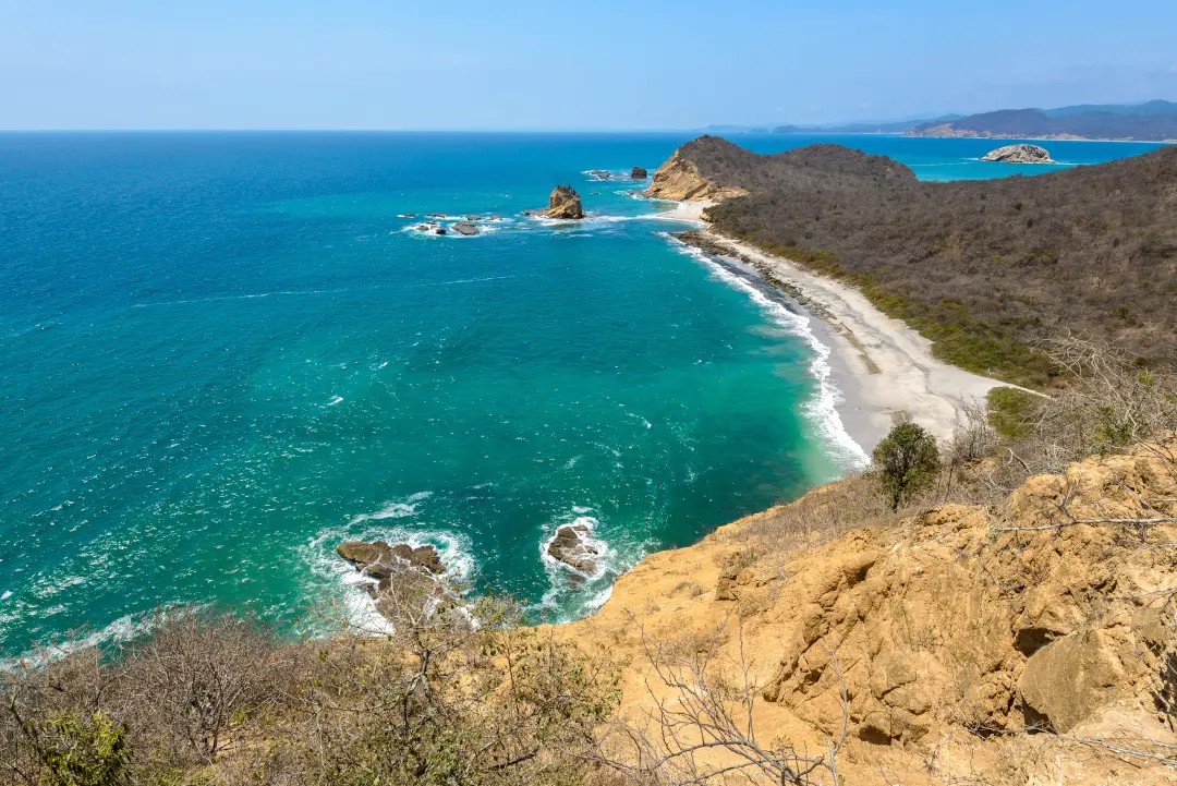 Playa virgen de la costa ecuatoriana con acantilados y formaciones rocosas