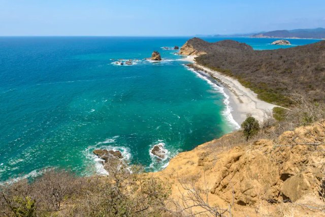 Playa virgen de la costa ecuatoriana con acantilados y formaciones rocosas