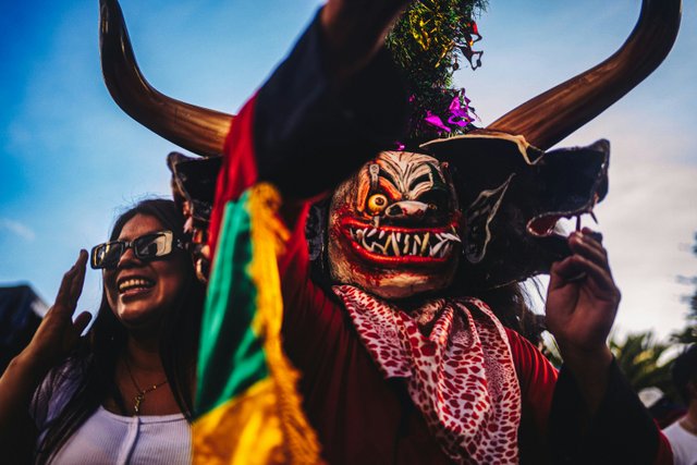 Festividad tradicional ecuatoriana con máscara de diablo