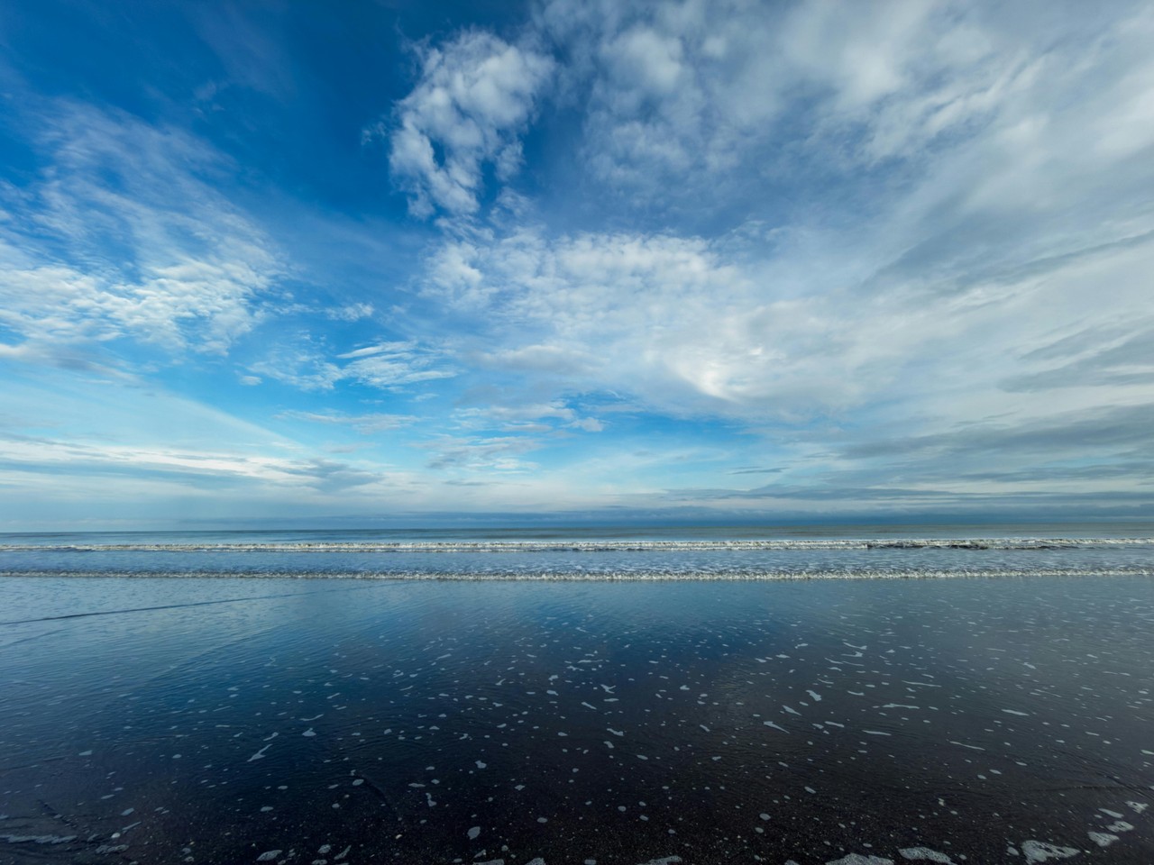 Playa serena de la costa ecuatoriana con cielo dramático