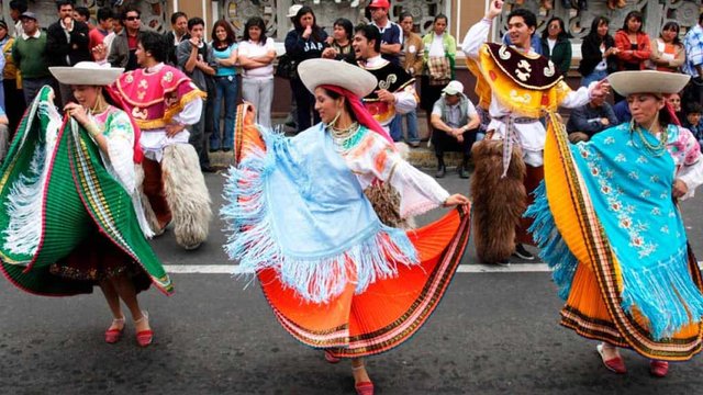 Danzantes en traje tradicional durante celebración festiva ecuatoriana