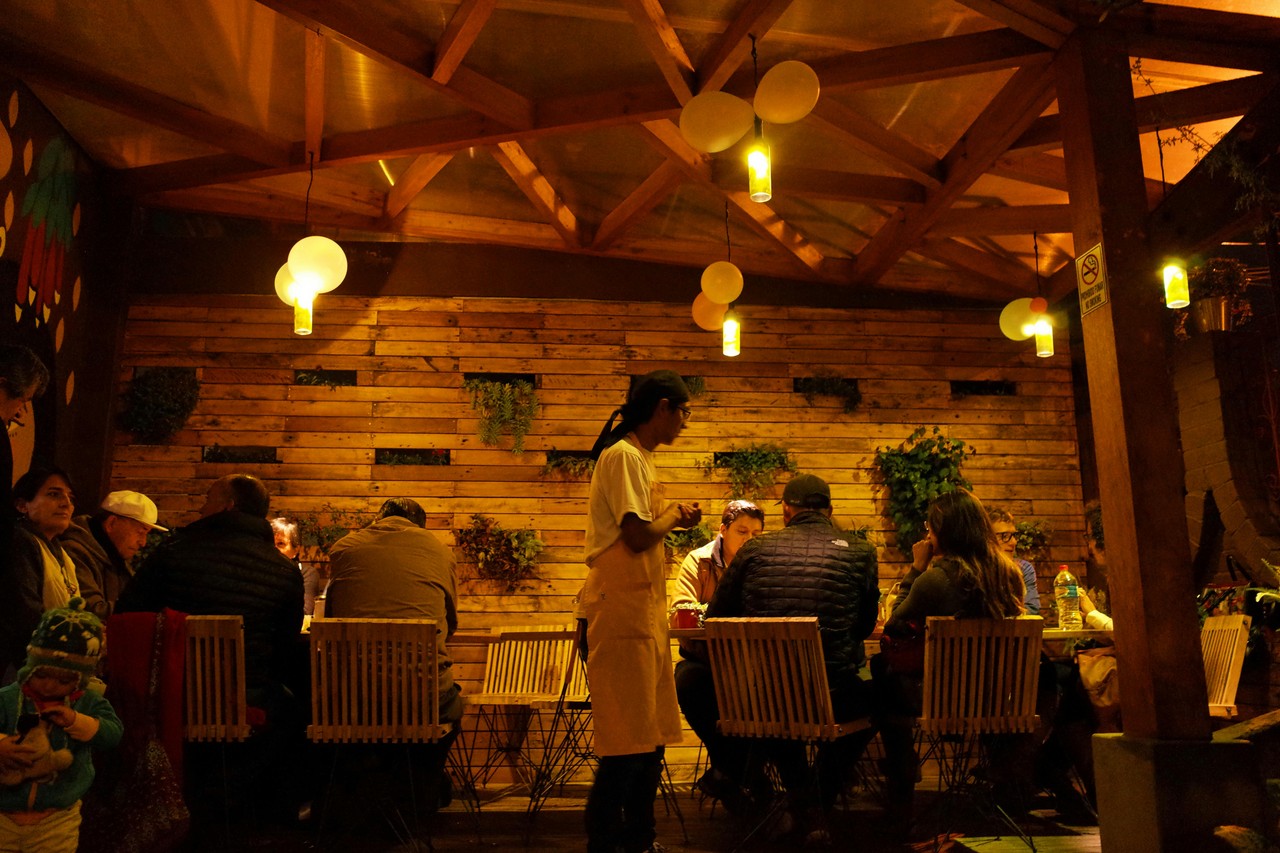 Ambiente cálido en restaurante ecuatoriano con comensales