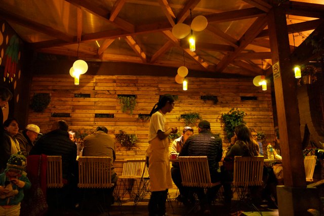 Ambiente cálido en restaurante ecuatoriano con comensales