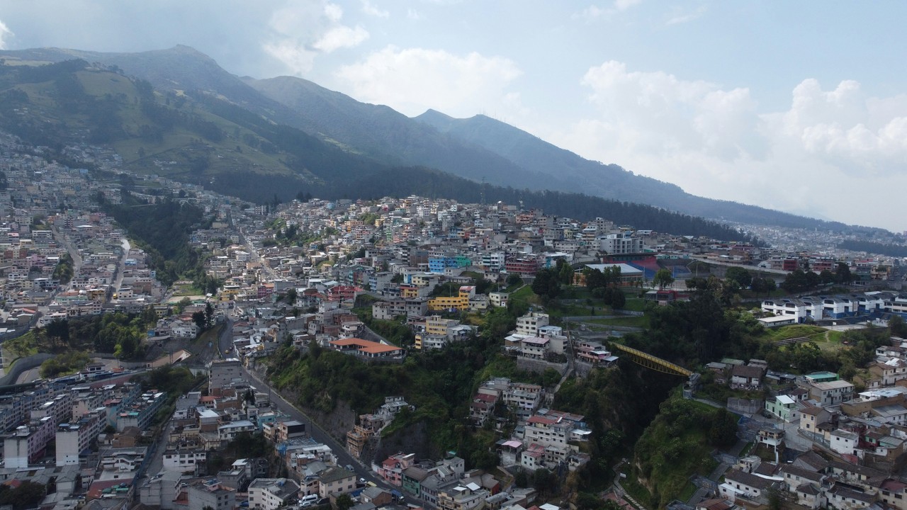Vista aérea de ciudad ecuatoriana con volcán al fondo