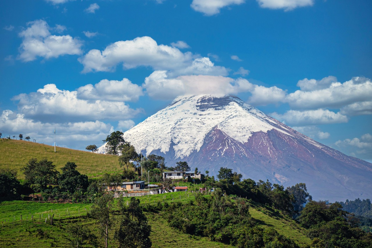 Volcán nevado de los Andes ecuatorianos con viviendas en las faldas