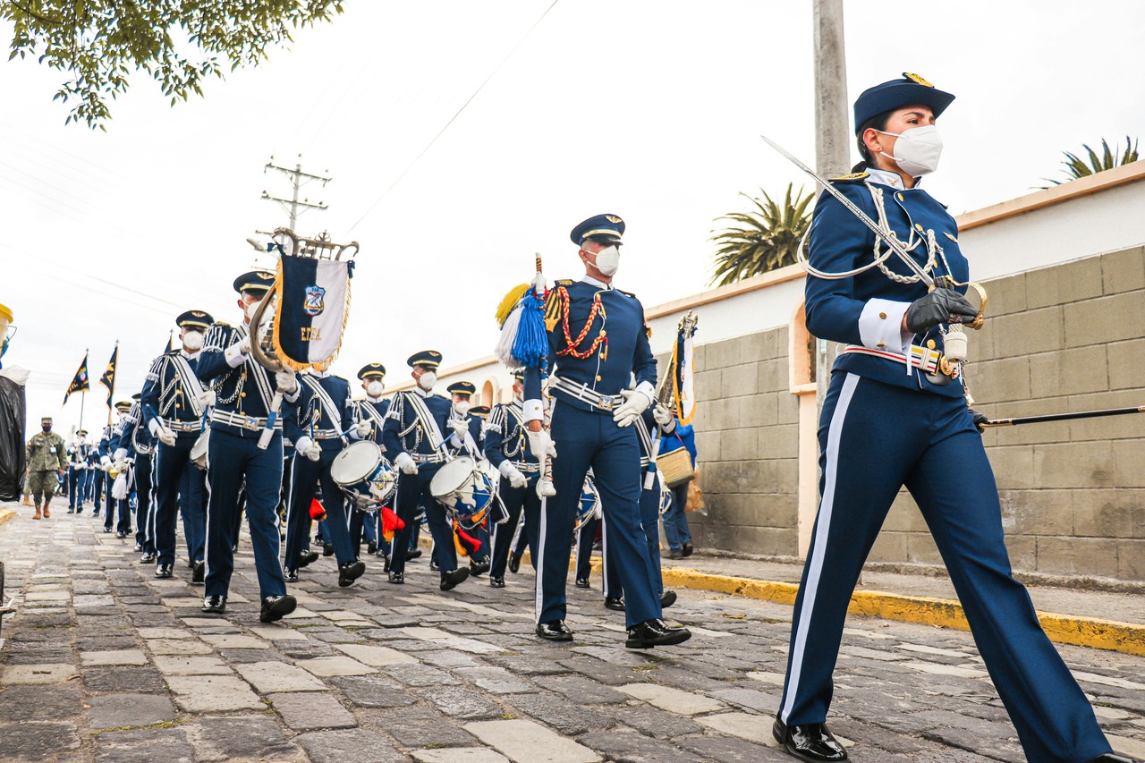 Procesión tradicional ecuatoriana con uniformes cívicos