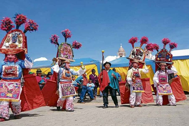 Festividad tradicional ecuatoriana con danzantes en trajes coloridos